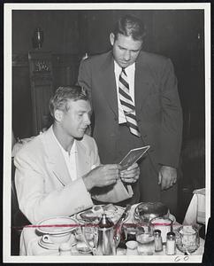 Storing up Energy in case he is called upon is today's game at Fenway Park is Detroit Pitcher Hal Newhouser, seated. He is checking the Hotel Kenmore menu with catcher Bob Swift.