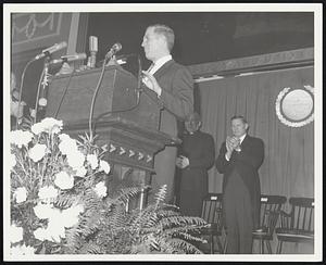 Kevin White at a podium, two unidentified people behind him