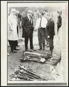 Ohio Gov. James A. Rhodes (second from left) confers with officials at Kent State University 5/3 where militants burned the Army ROTC building 5/2. Rifles, with wooden stocks burned away, are on ground in foreground.