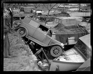 A car which has tipped over and hit a docked boat
