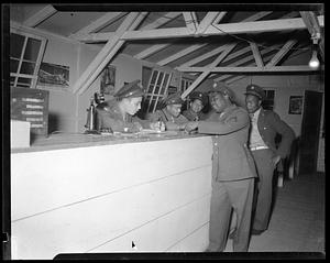 Soldiers at counter with telephone and paperwork