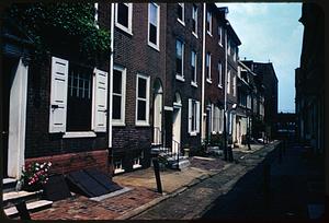 View down street with row of brick townhouses