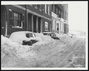 Plowing Held Up -- Owners of these cars parked at the foot of Chestnut street yesterday have made no effort to move them since they were buried in Saturday’s storm. As a result, only narrow lane is available for traffic.