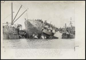 Ships Collide During Okinawa Typhoon--Wreckage of the S.S. ocelot lies awash in Buckner Bay, Okinawa, with the bow of an ARB (repair ship, battle damage) poking into the debris after the ships were driven together by the typhoon which swept the island Oct. 9. Some 130 Navy vessels were driven aground by the 140 mile-an-hour wind and 20 foot waves.