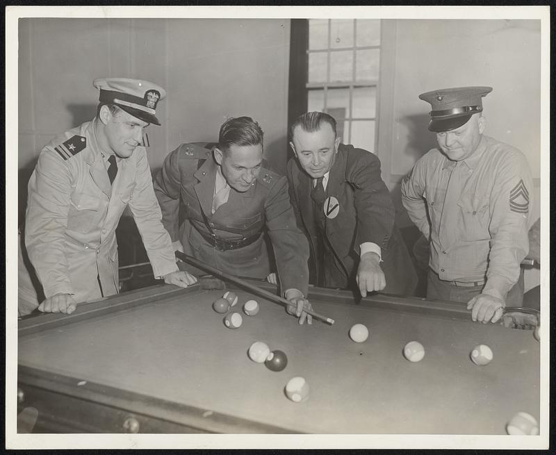 Erwin Rudolph, World Champion Billiard Player for five times shows U.S. Marine Captain Thos. Whitesel how to manage a difficult shot at U.S. Marine Barracks at Hingham, Mass. Rudolph is playing a series of exhibition matches for men in the service thuout the country under the auspices of the WPA War Mobile Unit at Hingham, and under the sponsorship of the Billiard Ass’n of America. He appeared at the Hingham Marine Ammunition Depot under the auspices of the WPA War Mobile Recreation Unit. Left to Right: Lt. P. Caswell, U.S. Navy; Capt. Thos. Whitesel, U.S. Marine Corps; and Erwin Rudolph, Five Times World Champion Billiard Player; and Sgt. Major, O.P. Olson, U.S. Marines.