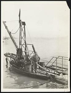 New Diving Tube for Salvage Work. Charles Courtney, master locksmith, is shown on a salvage boat at the top end of a new diving tube perfected by Simon Lake after Courtney inspected the apparatus Apr. 2 in the east river off Riker's Island, New York. Courtney represents a syndicate interested in the tube because the members plan to try to salvage the Lusitania.