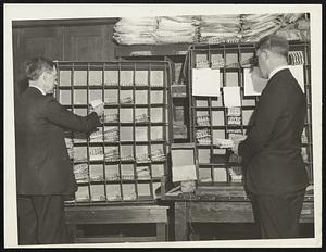 Putting the mail for the First Flight of the new Boston-Albany air mail service into pigeon-holes intended for distribution over a good part of the globe. There are about 5000 pieces of stamp collectors' "cachet overs" supplied by themselves at the Boston Post Office awaiting the start of flight tomorrow (Sunday) morning.