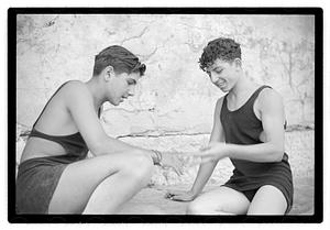 Two unidentified young men playing rock scissor paper