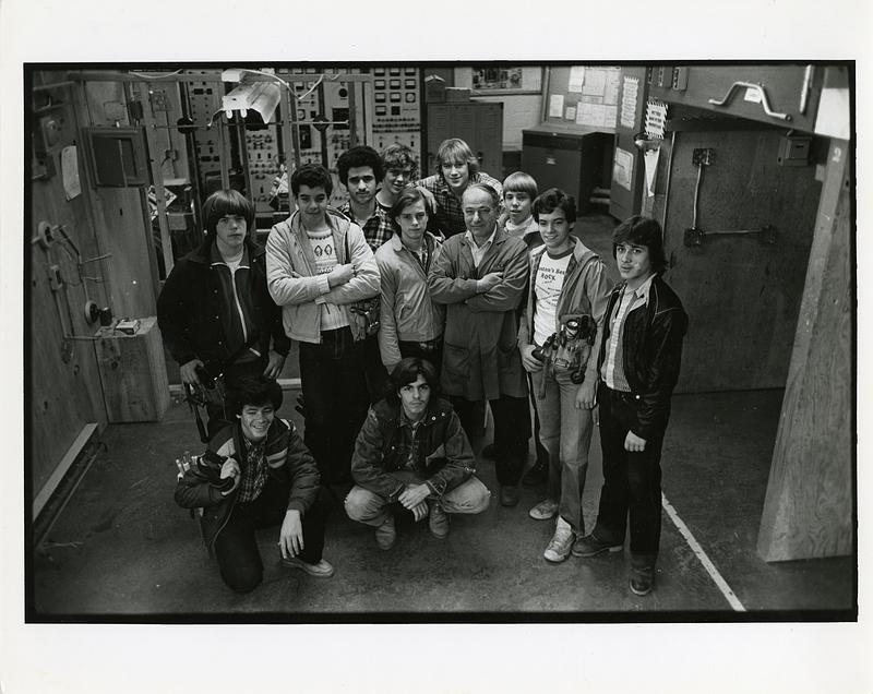 Students and teacher posing in mechanical room