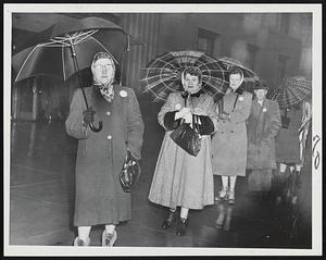 Rain Spattered Pickets on duty outside the telephone building on Franklin street. The picketing was started by striking Western Electric Co. employees from Watertown to induce long line operators to leave their boards.