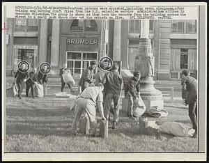Fourteen persons were arrested, including seven clergymen, after seizing and burning draft files from the U.S. selective service administration offices in downtown Milwaukee. The group is shown as they took the records from the building across the street to a small park where they set the records on fire.