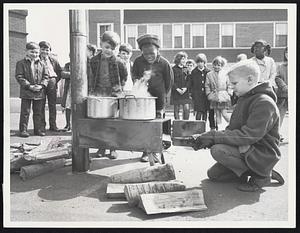 How Sweet It Is! Robert Waterman, left and William Bell, third graders at the Andrew School in Southie seem to be saying as fifth grader Allan Ernst strokes the fire underneath pots of boiling sap.
