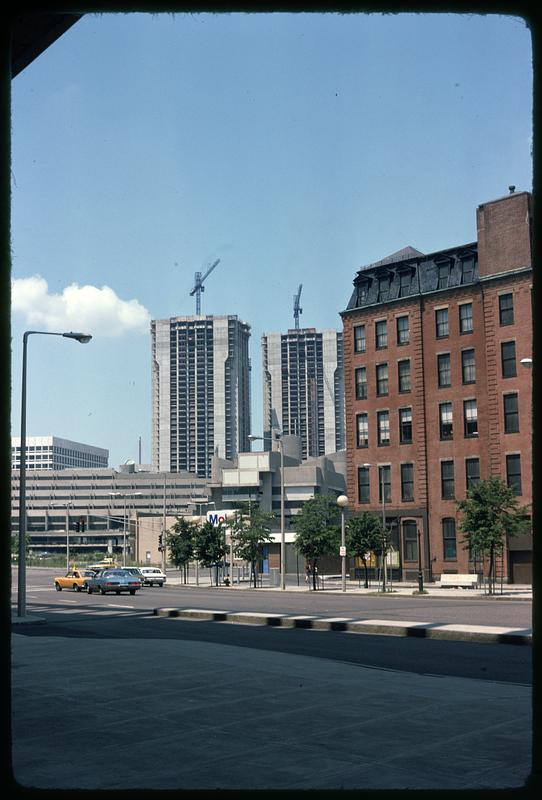 Cranes above skyscrapers being built, street in foreground