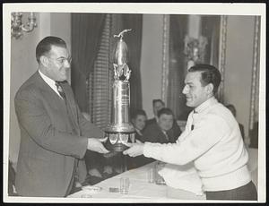 [S]ome 150 school football champions were guests of the Interscholastic Sportswriters' Association at the Hotel Lenox last night, and while all teams received awards, the major ones went to Lynn English in baseball and Brockton in football. On the left is Capt. Jim Hegan of Lynn nglish receiving the James C. O'Leary trophy from James C. O'Leary himself, while on the right is Capt. Frank Saba o Brockton accepting the Fred J. O'Brien football trophy from Joe McKenney, associate director of physical education in the Boston schools.