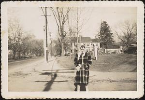 Woman, possibly Marilyn Morse, standing at the corner of Main Street and High Street with the Congregational Church on the right