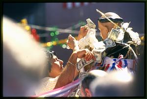 Boston: A statue of St. Anthony is carried the city's N. End during the annual St. Anthony's Feast - 2002. Boston: A woman places a donation on The statue of St. Anthony 2002