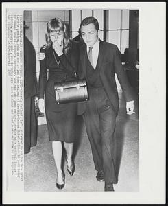 Sobbing Protege, Left--Beverly Aadland, left, referred to as the late Errol Flynn's protege, sobs as she is led down hallway at Seattle-Tacoma International Airport today by Ronald Shedlo, Flynn's secretary. She had just been refused service at a cocktail lounge because, employes said, she is under age. Miss Aadland and Shedlo are enroute to Los Angeles.