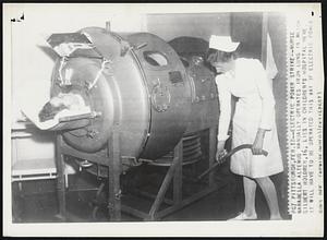 Electric Power Strike--Nurse Marabella Altemus Manually operates iron lung in which Gilbert Holdren, 16, lies in children's hospital here it will have to be operated this way if electric power goes off.