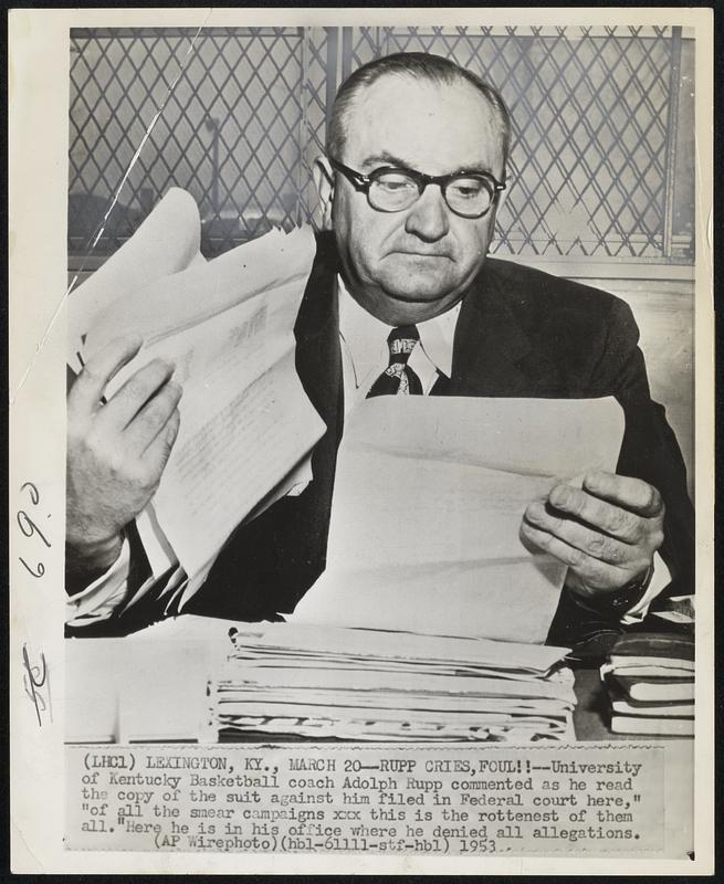 Rupp Cries, Foul!! -- University of Kentucky Basketball coach Adolph Rupp commented as he read the copy of the suit against him filed in Federal court here, "of all the smear campaigns xxx this is the rottenest of them all." Here he is in his office where he denied all allegations