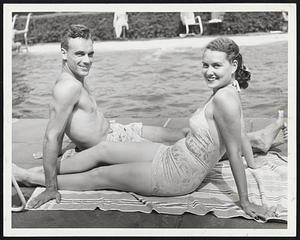 Victor of Tennis and His Missus-They are Mr. and Mrs. Victor Seixas of Philadelphia, currently part of the show in the national doubles tennis championships at Longwood, Husband Vic as an on-court start and Dolly Ann Seixas merely as just about the best looker backstage. The setting, but naturally, is the Longwood pool.