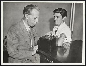 Principal Demonstrates Protested "Detector" With Tony Aquanno of the School's Safety Patrol as His Subject, Principal Gray Moreland of Newton Street Grammar School Here, Demonstrates the Fake Lie Detector He Used to Make Students Confess Errors. Practice Has Been Protested by Parents and Psychiatrists.