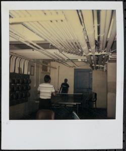 Two boys playing ping pong in the basement