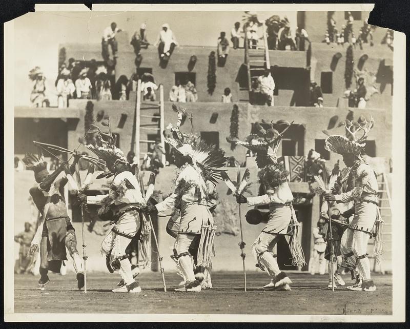 Annual Deer Dance by Indians. Gorgeously arrayed, young braves of the San Juan Indian tribe of New Mexico, danced the deer dance at the annual Indian Ceremonial in Albuquerque, N.M., August 31. Spectators seated themselves as shown here.