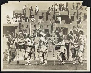 Annual Deer Dance by Indians. Gorgeously arrayed, young braves of the San Juan Indian tribe of New Mexico, danced the deer dance at the annual Indian Ceremonial in Albuquerque, N.M., August 31. Spectators seated themselves as shown here.