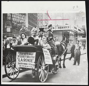 Off-Broadway Performers – Showgirls ride in horse-drawn carriage through Times Square to drum up business for their off-Broadway show during blackout of Broadway theaters. Actors’ strike has closed New York’s major productions and off-Broadway theaters are reaping a bonanza. Story on Page 2.