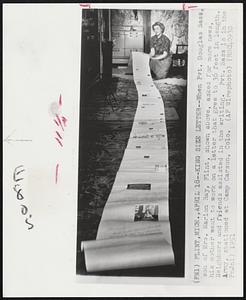 King Size Letter--When Pvt. Douglas Sass, son of Mrs. Marion Ray, Flint, shown above, asked for more news, his mother went to work on a letter that grew to 36 feet in lenght. Neighbors and friends assisted in the writing. Pvt. Sass is in the Army, stationed at Camp Carson, Colo.