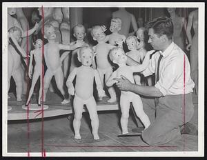 The Mannequin Master, John De Stefano, examines finished products in form-filled Elm street loft. Store window dummies are at once finished products and raw material for more dramatic historical tableaux and displays.