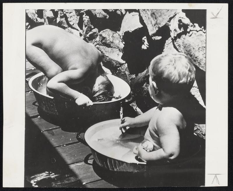 Sure is Cool in Here-Linda Palmer, 2 1/2 years old, finds that just sitting isn't cool enough, so she decided to try dunking her head to overcome the high temperature at Santa Barbara, Calif. Her brother, Ken, one year old, watches.