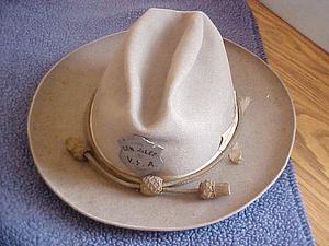 Light hat with badge and decorative cord