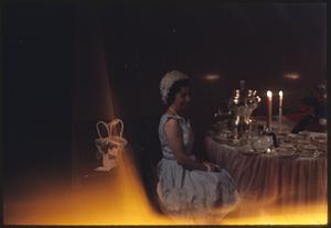 Woman sitting at table with lit candles