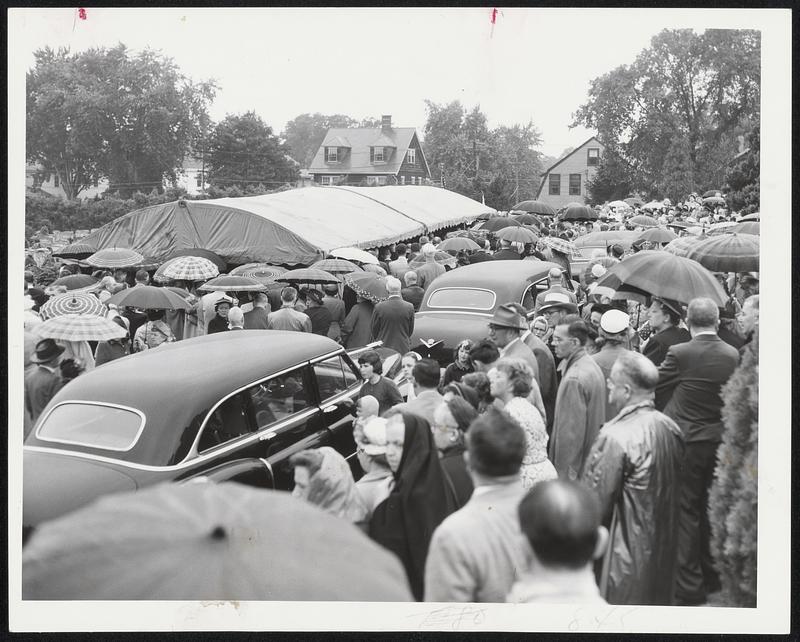 Mourners at Grave – A silent and reverent crowd, some protected from the weather by umbrellas, stand outside the canopy at Holyhood cemetery, Brookline, where the body of Maurice J. Tobin was laid to final rest today.