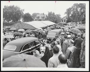 Mourners at Grave – A silent and reverent crowd, some protected from the weather by umbrellas, stand outside the canopy at Holyhood cemetery, Brookline, where the body of Maurice J. Tobin was laid to final rest today.