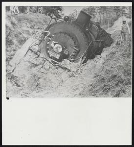 A Landslide trapped this locomotive of an Illinois Central freight train near Ackerman, Miss. The huge engine plowed into the mass of earth on the track as the train rounded a curve. A hill prevented the engineer from seeing the dirt until it was too late to stop. The locomotive and four cars were derailed but nobody was hurt. Heavy rain caused the landslide.