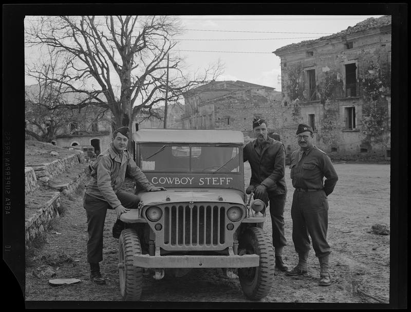 Men in uniform posing with car