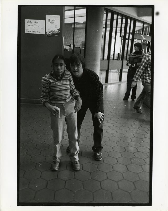 Two students posing in school hallway