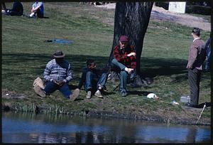 People sitting and standing at water's edge