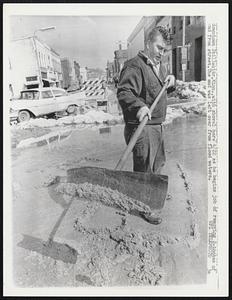 Downtown Stillwater, Minn., with shovel here 4/22 as he begins job of removing 2-inches of mud from street. The mud was left over from flood waters.