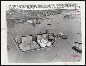 Port Cargill grain terminal at Savage, Minn., was flooded here 4/13 except for a grain elevator complex that 150 Cargill employes were working to save. The grain terminal is located on the Minnesota River and the city of Savage is pictured in the background.