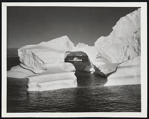 Ice Peek. Framed in the arch of a starkly beautiful iceberg, a petrol boat of the International Ice Patrol presents a cool picture. The berg’s archway was caused by a “fault” or air pocket which will cause it to melt rapidly when it reaches the Gulf stream. After breaking off from the Greenland ice cap, some bergs meander for more than two years and travel some 2,000 miles. When afloat, approximately 9/10ths of their bulk is submerged. The ice patrol, which charts their wanderings and alerts ships to the movement of ice flows, takes a dim view of ocean liners that come close to icebergs so passengers can obtain photographs.