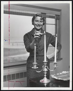 Getting Ready for Edna, pretty Nancy Janice Canavan, 15, a Revere high school junior, lights candles in her home at Point of Pines. The candle at left was used when power failed during Hurricane Carol.