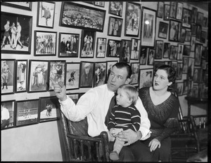 Jack Sharkey with wife and son points out boxing photos at his Chestnut Hill home