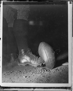 Stop action close-up of Wes Fesler of Harvard kicking ball
