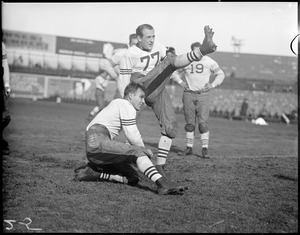 "Red" Grange kicking as Carl Brumbaugh holds - quarterback for Chicago Bears. Braves field, Boston.