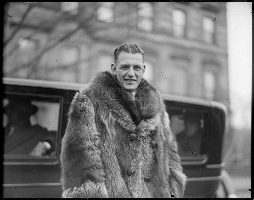 Red Grange, football star, wearing fur coat during visit to Boston