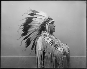 George Levi, Haskell Indian star, salutes wearing war bonnet