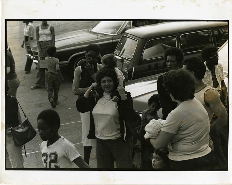 People and children gathered in a parking lot